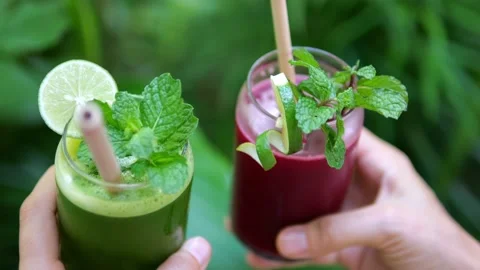 Close-up in the hands of two glasses with fresh smoothies from various fruits Stock Footage 197904259