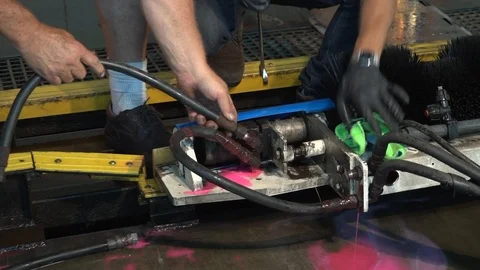 Close up of hands as two technicians fix a hydralic leak inside a car wash Stock Footage 96007574