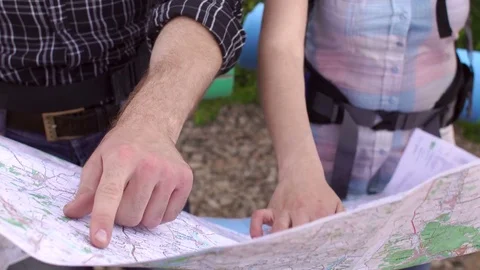 Close-up of the hands of two tourists on the map. Stock Footage