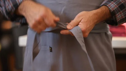 Close up of hands tying an apron around waist. Preparing food in the kitchen. Stock Footage 106078221