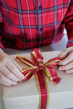 Close-Up of Hands Tying Bow on Gift Box Stock Photos