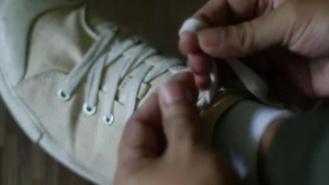 Close up hands tying white canvas sneakers shoelaces Stock Footage 319523000