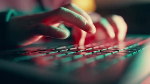 Close-up of Hands Typing on Backlit Keyboard in Dark Room Stock Footage 346151323