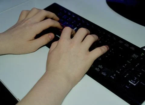 Close-up of Hands Typing on a Black Computer Keyboard 写真素材