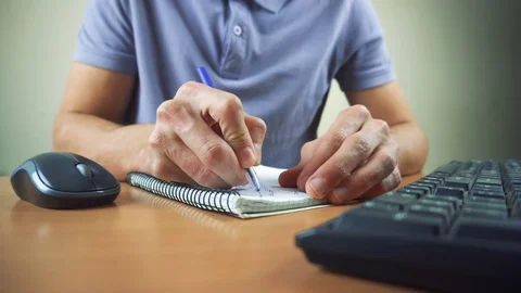Close up of hands typing on computer keyboard and mouse. Writing in notebook Stock Footage 84281090