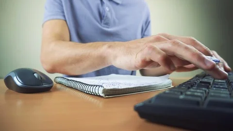 Close up of hands typing on computer keyboard and mouse. Writing in notebook Stock Footage 84281202