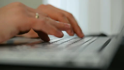 Close up of hands typing on a computer keyboard in an office environment, Video stock 335948472
