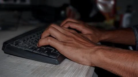 Close up of hands typing on computer keyboard lying on a wooden table. Illustrazione stock