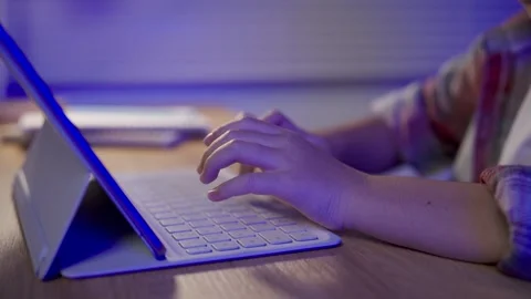 Close up of hands typing on keyboard attached to tablet device on wooden de.. Stock Footage 341459248