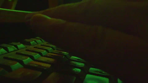 Close up of hands typing on keyboard in dark room, low key lighting Stock Footage 335635965