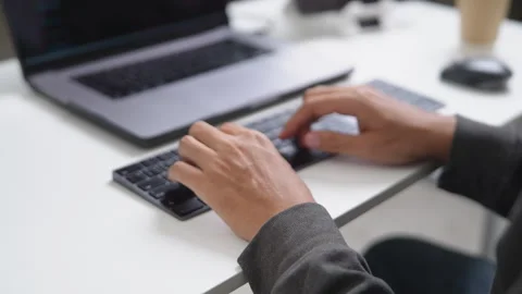 Close-up of Hands Typing on a Keyboard During Remote Work Setup with Technolo Stock Footage 336679779