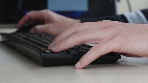 Close-up of hands typing on keyboard in modern office setting Stock Footage 309276637