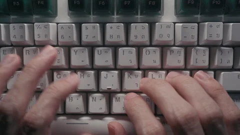 Close-up of Hands Typing on a Keyboard with Thai and English Characters Stock Footage 330257878