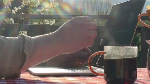 Close up of hands typing on laptop with coffee outdoors Stock Footage 333526596