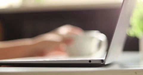 Close-up of hands typing on a laptop with a coffee cup nearby Stock Footage 339074782