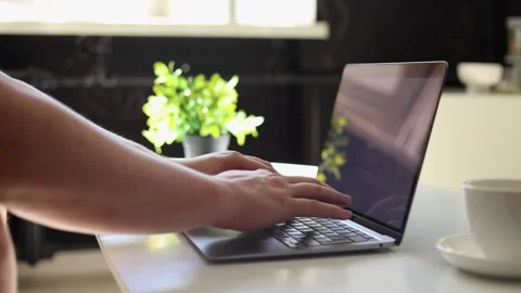 Close-up of hands typing on a laptop with a coffee cup nearby Stockbeeldmateriaal 342280465