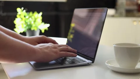 Close-up of hands typing on a laptop with a coffee cup nearby Vidéo 342280486