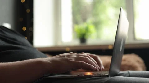 Close-up of hands typing on a laptop with a cozy, blurred background Stock Footage 340264840