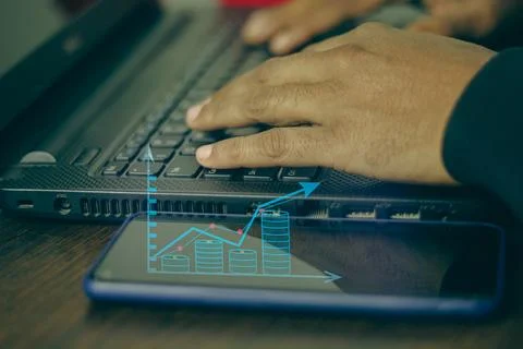 Close-up of hands typing on a laptop with growing up business graph on a mo.. Stock Illustration