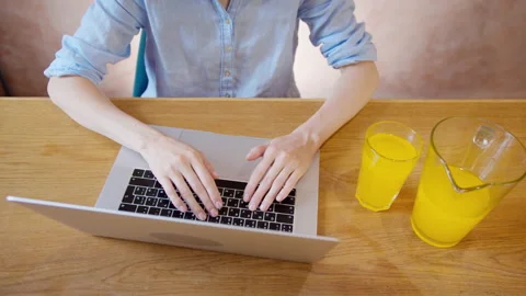 Close-up hands typing on laptop keyboard at the table. Video stock 134576210