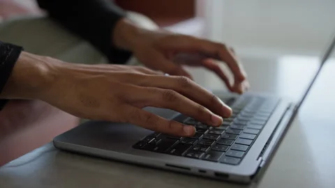 Close-up of hands typing on laptop keyboard in modern workspace Stock Footage 292775010