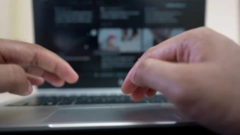 Close-up of hands typing on a laptop keyboard, blurred screen in background Stock Footage 317737503