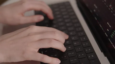 Close-up of hands typing on laptop keyboard with crypto trading platform on Stock Footage 317952218