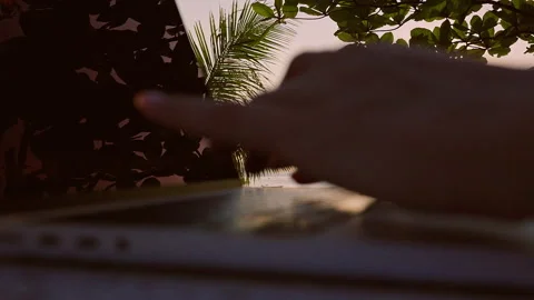 Close Up of Hands Typing on Laptop Keyboard with Warm Sunset Light at Seaside, R Stock Footage 332305838
