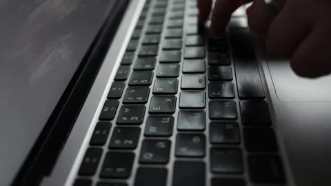 Close-up of hands typing on a laptop keyboard with a ring on one finger Stock Footage 338999526