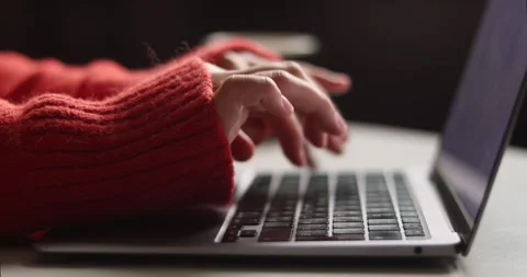 Close-up of hands typing on a laptop keyboard in a cozy sweater Stock Footage 339072475