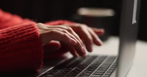 Close-up of hands typing on a laptop keyboard wearing a cozy sweater Stock Footage 339072555