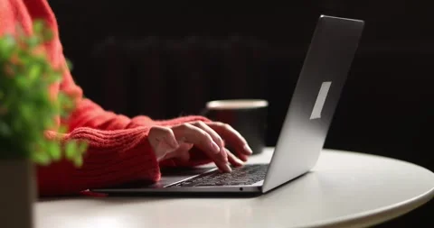 Close-up of hands typing on a laptop keyboard while wearing a cozy sweater Stock Footage 339072714