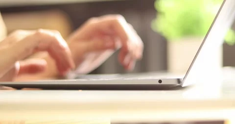 Close-up of hands typing on a laptop keyboard, focusing on digital work and Stock Footage 339074734