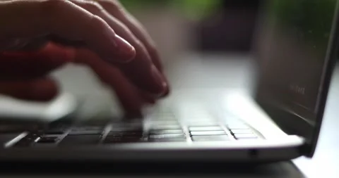 Close-up of hands typing on a laptop keyboard in soft, natural light Stock Footage 339074822