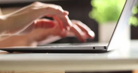 Close-up of hands typing on a laptop keyboard with a blurred background Stock Footage 339074890