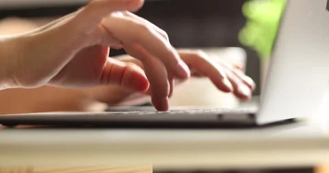 Close-up of hands typing on a laptop keyboard with a blurred background Stock Footage 339075047