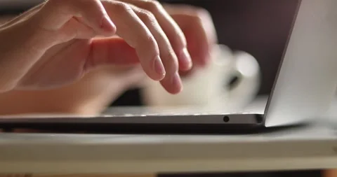 Close-up of hands typing on a laptop keyboard with soft lighting Stock Footage 339075429