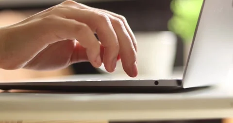 Close-up of hands typing on a laptop keyboard in a bright, natural setting Stock Footage 339075688