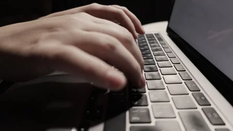 Close-up of hands typing on a laptop keyboard in low light, focusing on the keys Stock Footage 339174388