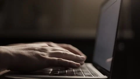 Close-up of hands typing on a laptop keyboard in low light conditions Stock Footage 339174533