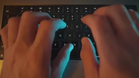 Close up on hands typing on laptop keyboard in dark office desk at night Stock Footage 340234025