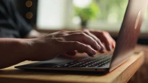 Close-up of hands typing on a laptop keyboard with soft natural light Stock Footage 340264322