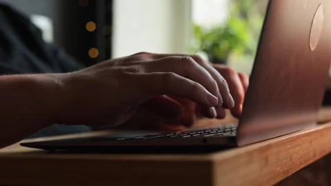 Close-up of hands typing on a laptop keyboard in a well-lit room Stock Footage 340264579