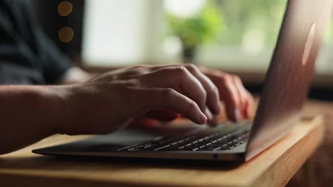 Close-up of hands typing on a laptop keyboard in a bright, natural setting Stock Footage 340265079