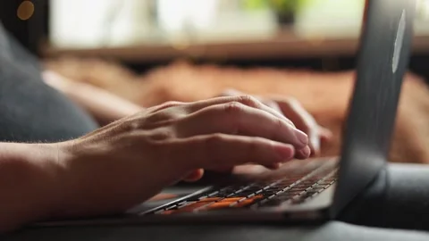 Close-up of hands typing on a laptop keyboard in a cozy indoor setting Stock Footage 340265094