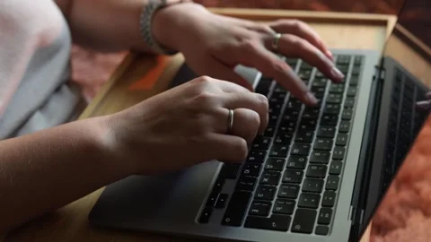 Close-up of hands typing on a laptop keyboard in a cozy indoor setting Stock Footage 340265280