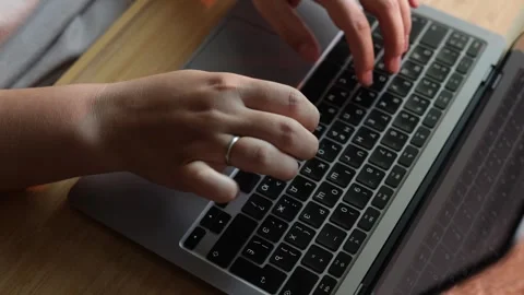 Close-up of hands typing on a laptop keyboard with a wedding ring Stock Footage 340265990