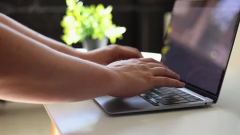 Close-up of hands typing on a laptop keyboard in a well-lit office environment Vidéo 342280449