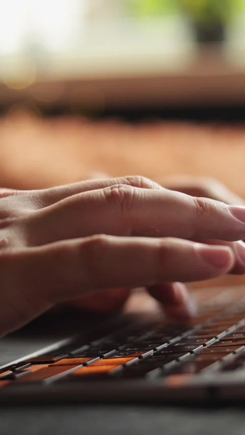 Close-up of hands typing on a laptop keyboard with soft natural light Vidéo 343838046