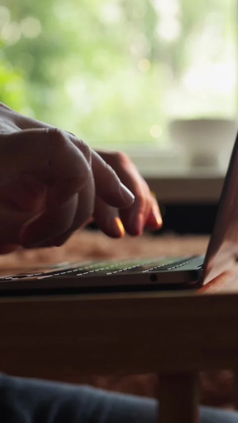 Close-up of hands typing on a laptop keyboard with a blurred natural background Stock-Footage 343838118